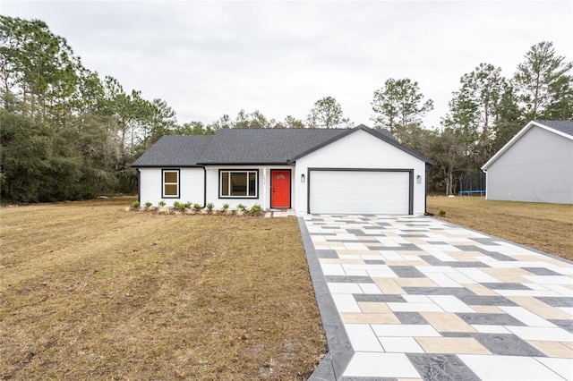 view of front of property with a garage, a front yard, and a trampoline