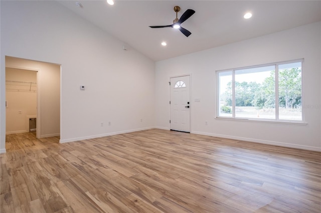 unfurnished living room with high vaulted ceiling, ceiling fan, and light hardwood / wood-style floors