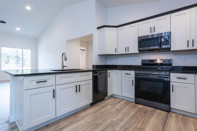 kitchen featuring sink, white cabinetry, black appliances, and kitchen peninsula