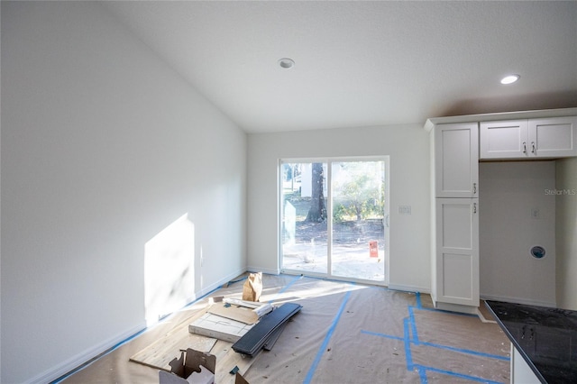 unfurnished living room with recessed lighting and baseboards