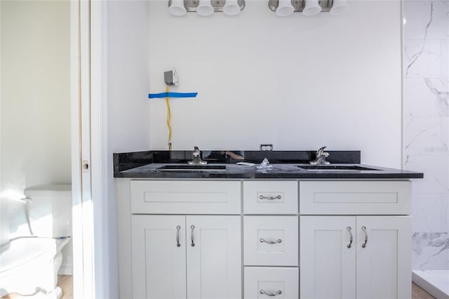 full bath featuring a sink, toilet, and double vanity