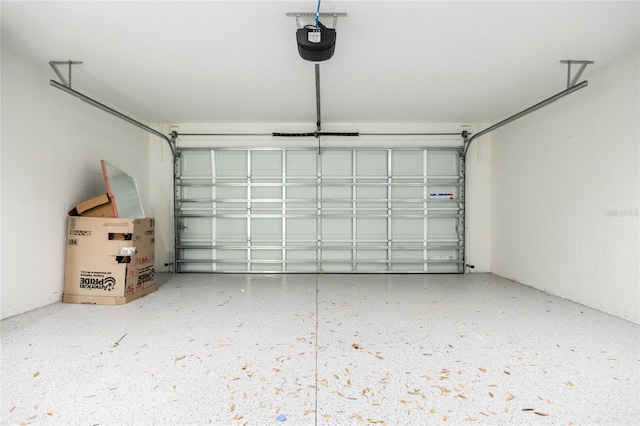 garage with concrete block wall and a garage door opener