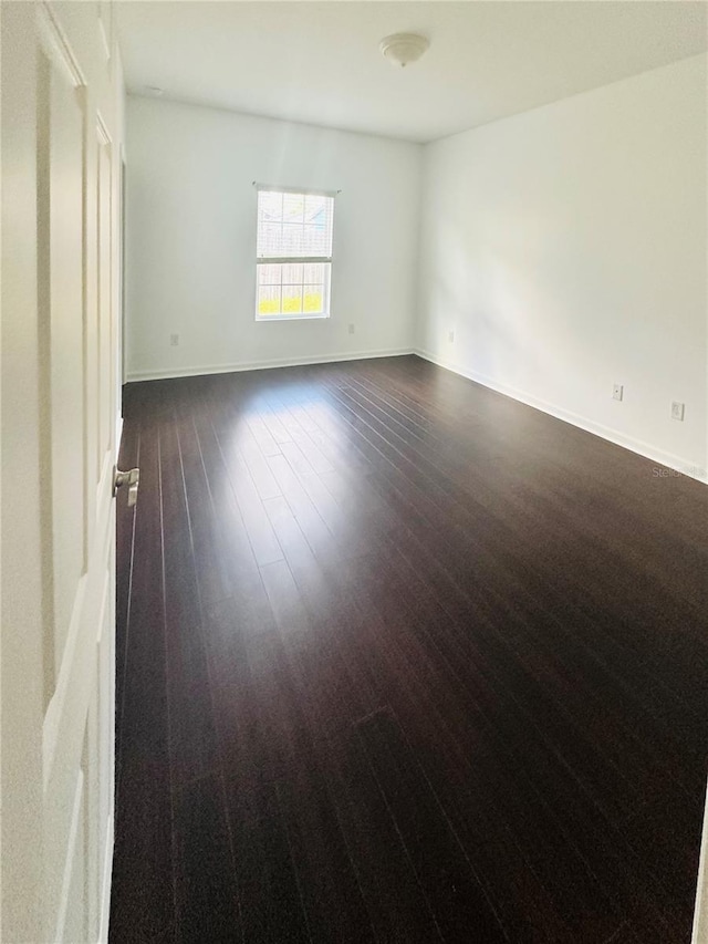 empty room with dark wood-type flooring