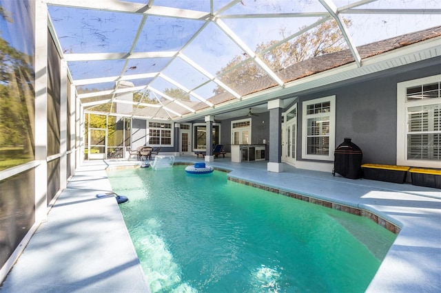 view of swimming pool with a hot tub, a patio area, a lanai, and ceiling fan