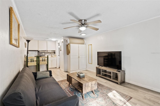 living room with sink, ceiling fan, a textured ceiling, and light hardwood / wood-style floors