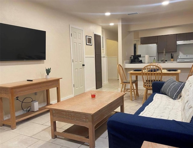 living room featuring light tile patterned floors and sink