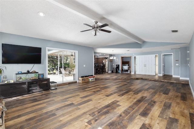 living room with lofted ceiling with beams, ceiling fan with notable chandelier, a textured ceiling, and dark hardwood / wood-style flooring