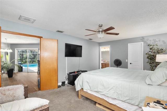 bedroom featuring ensuite bath, ceiling fan, a textured ceiling, light colored carpet, and access to outside