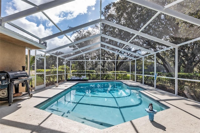 view of swimming pool with area for grilling, glass enclosure, and a patio area