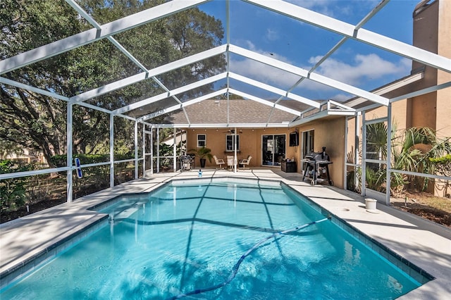 view of swimming pool featuring a patio, area for grilling, and glass enclosure