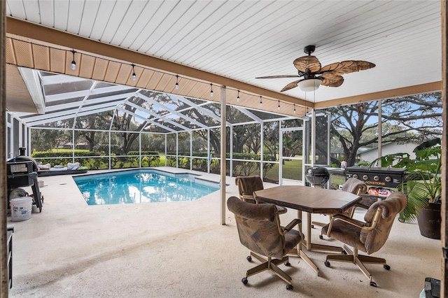 view of swimming pool featuring ceiling fan, a mountain view, glass enclosure, and a patio area