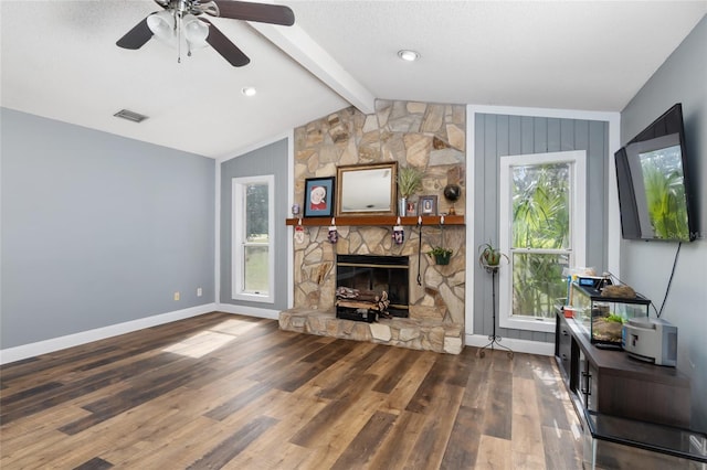 living room featuring lofted ceiling with beams, a wealth of natural light, a fireplace, and dark hardwood / wood-style flooring