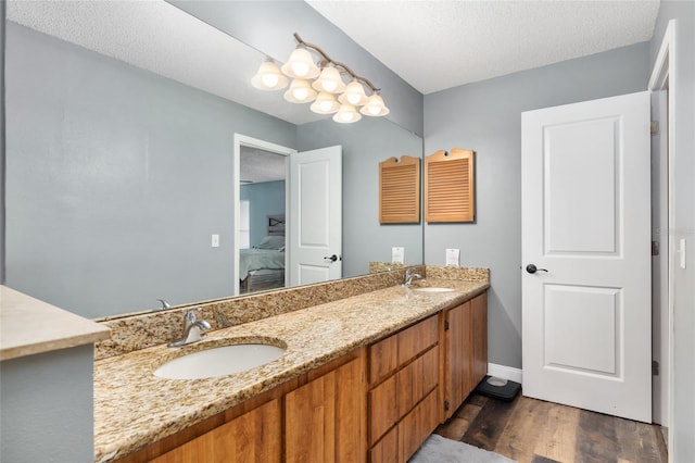 bathroom featuring wood-type flooring, vanity, and a textured ceiling