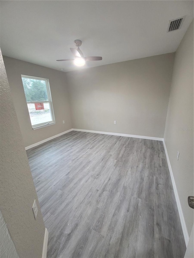 empty room with ceiling fan and wood-type flooring