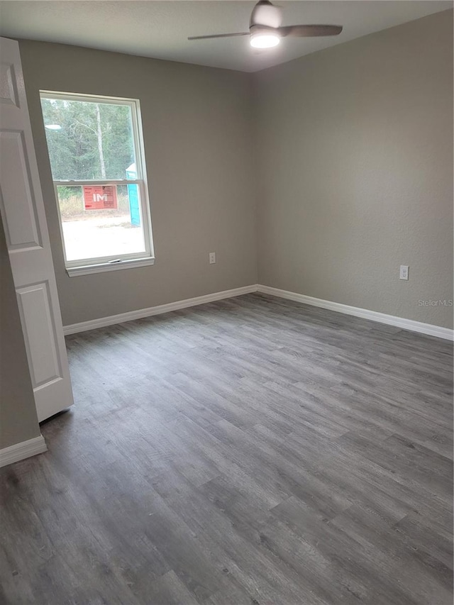 spare room with ceiling fan and dark wood-type flooring