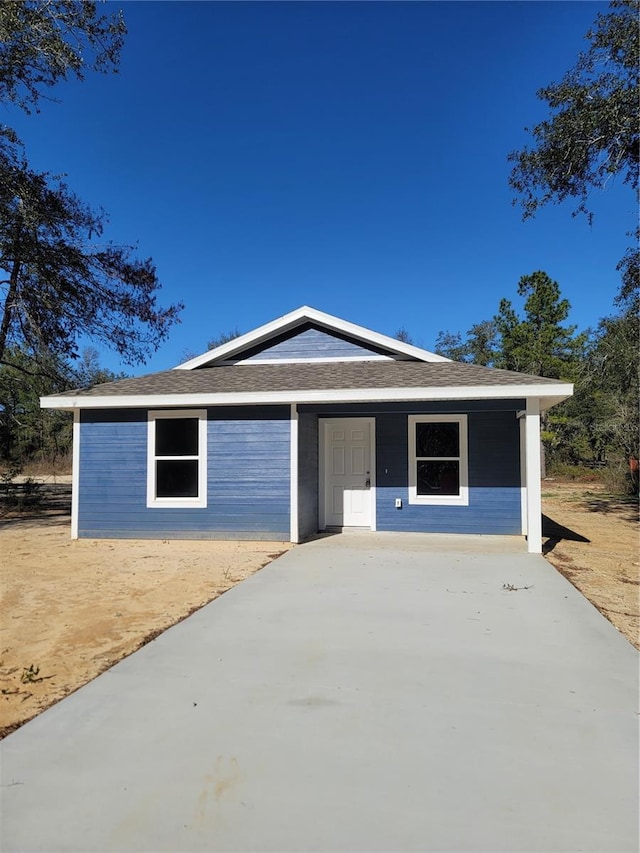 ranch-style home with roof with shingles