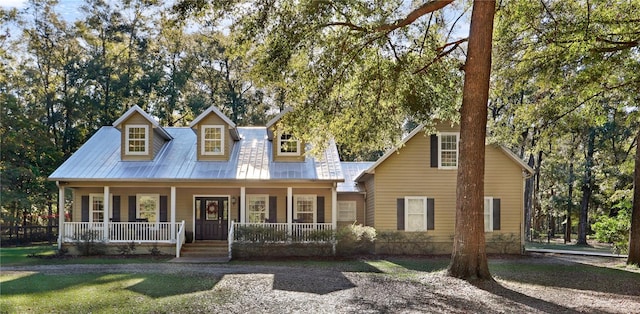 cape cod house featuring a porch and metal roof