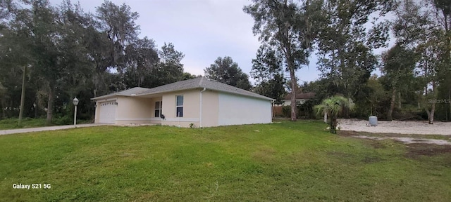 view of side of home featuring a yard and a garage