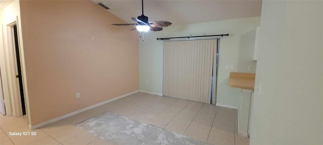 unfurnished room with ceiling fan, lofted ceiling, and light tile patterned flooring