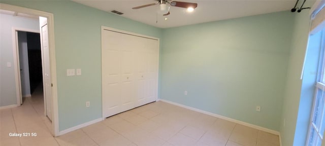 unfurnished bedroom featuring ceiling fan, a closet, and light tile patterned flooring