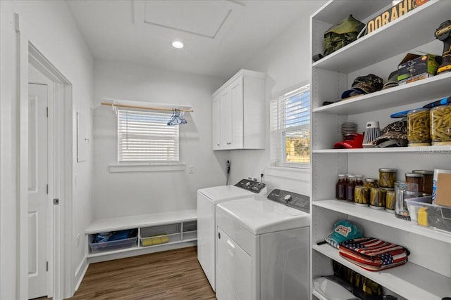 laundry room with dark wood-type flooring, cabinets, and washing machine and dryer