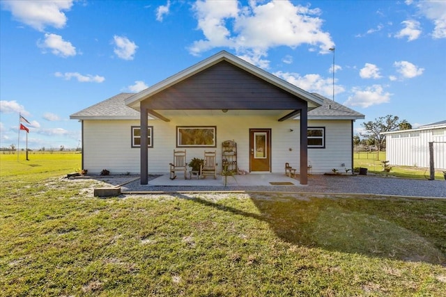 back of house featuring a patio and a yard