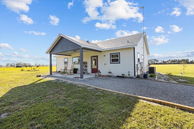 back of house with a patio, cooling unit, a yard, and a rural view