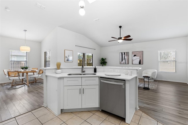 kitchen featuring visible vents, a sink, light countertops, stainless steel dishwasher, and open floor plan