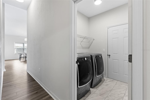 laundry room featuring laundry area, washing machine and dryer, marble finish floor, and baseboards