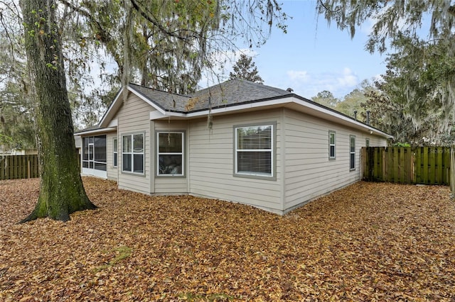 back of house with a fenced backyard and a sunroom