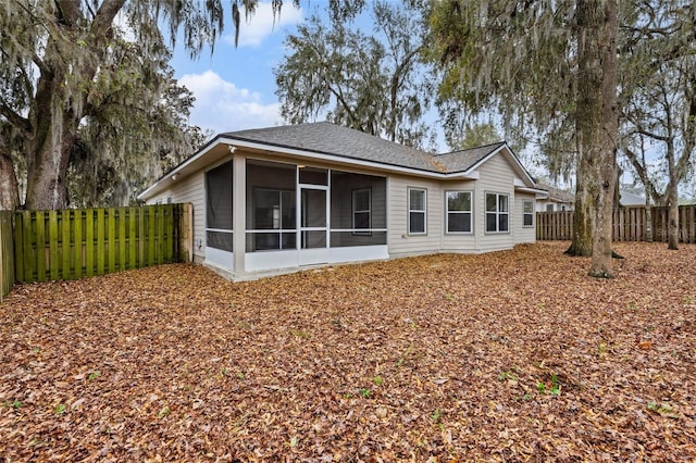 back of house with a fenced backyard and a sunroom