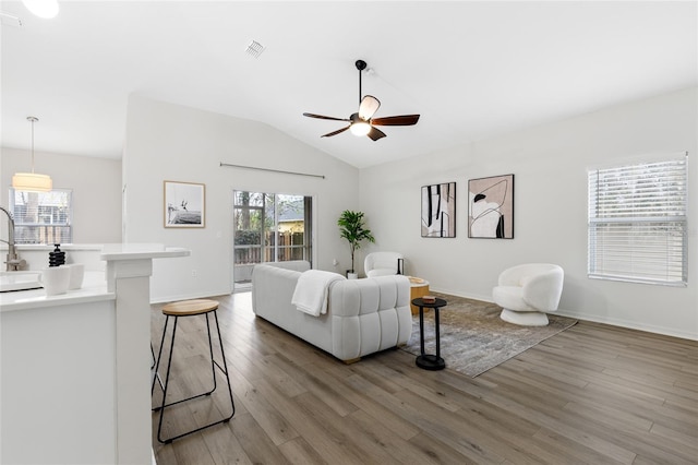 living room with lofted ceiling, light wood-style floors, and a wealth of natural light