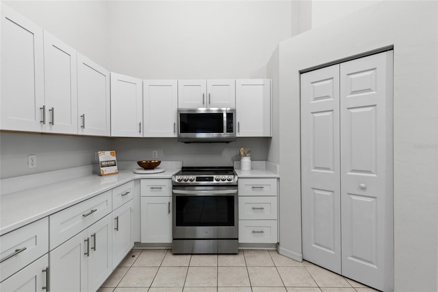 kitchen with white cabinetry, light countertops, light tile patterned floors, and stainless steel appliances