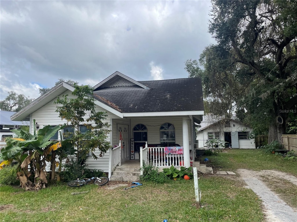 bungalow with a porch and a front lawn