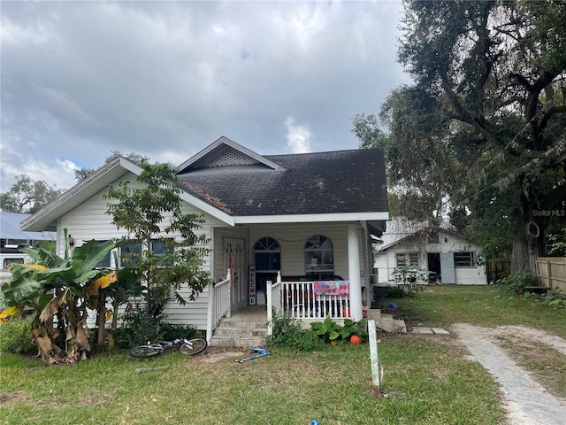 bungalow with a porch and a front lawn