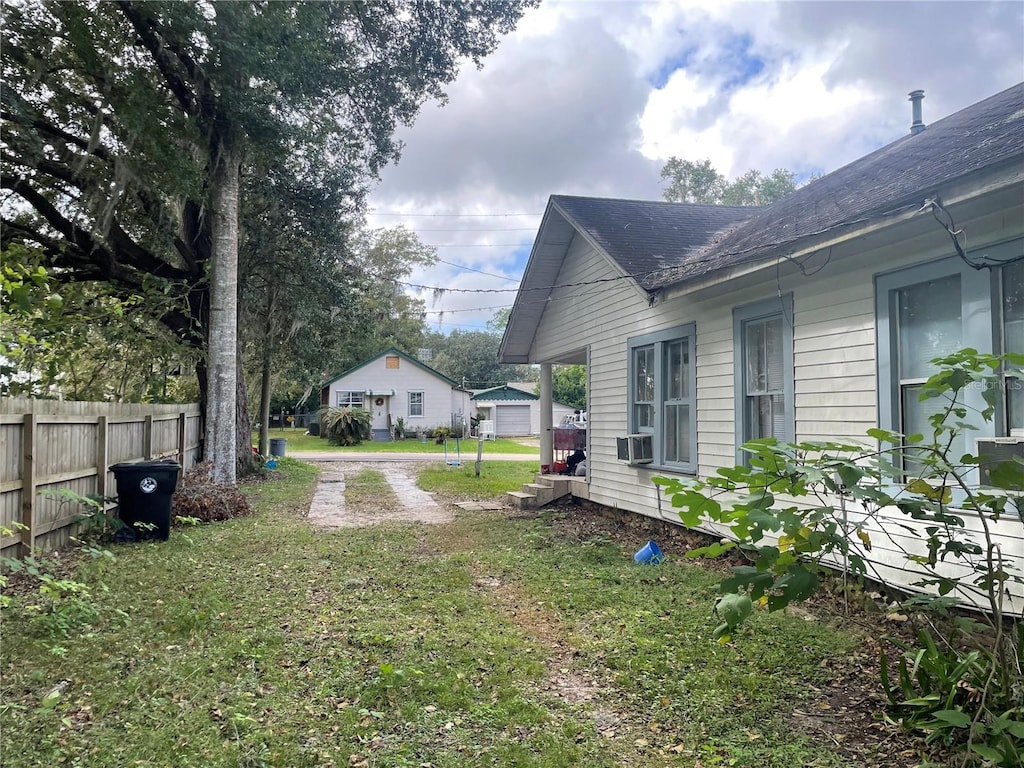 view of yard featuring a garage and cooling unit