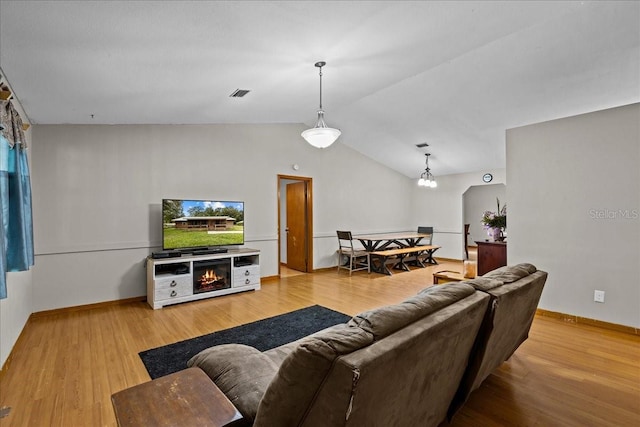 living room with vaulted ceiling and light hardwood / wood-style floors