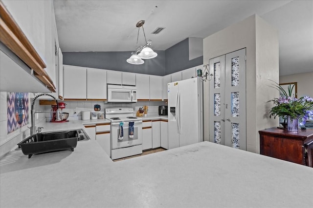 kitchen with white cabinets, decorative backsplash, hanging light fixtures, sink, and white appliances