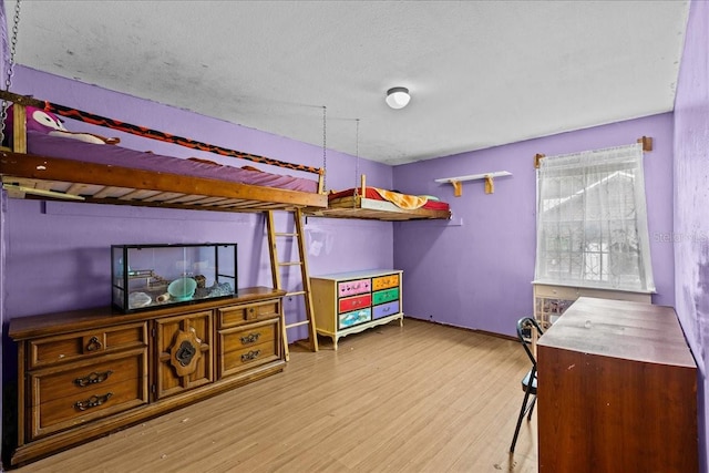 bedroom with a textured ceiling and light wood-type flooring