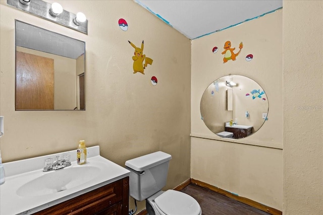 bathroom featuring toilet, vanity, and wood-type flooring