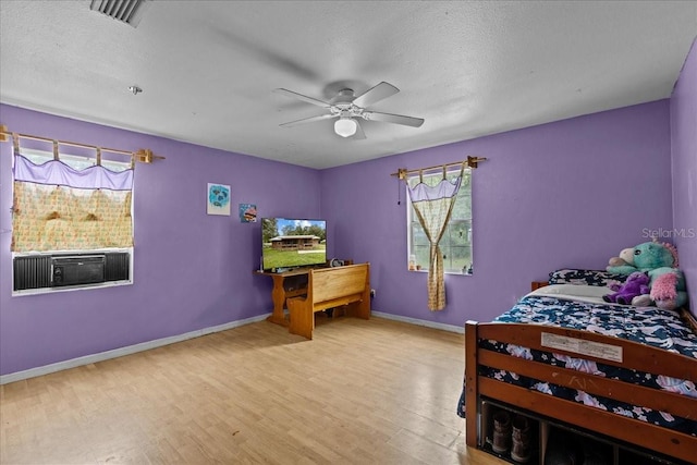 bedroom featuring a textured ceiling, light hardwood / wood-style floors, and ceiling fan