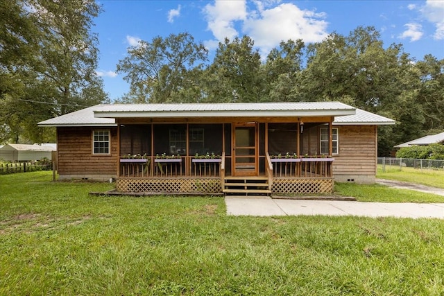 view of front of home featuring a front yard and a sunroom