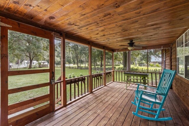 unfurnished sunroom featuring wooden ceiling and ceiling fan