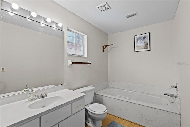 full bathroom featuring toilet, a garden tub, visible vents, and vanity