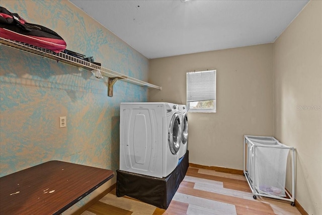 clothes washing area featuring wallpapered walls, baseboards, laundry area, and independent washer and dryer