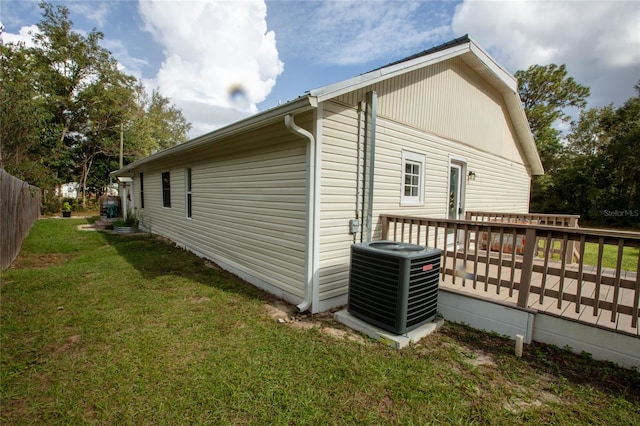 view of side of home featuring a yard, central AC, and a deck