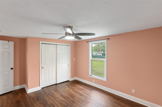 unfurnished bedroom featuring a closet, ceiling fan, and dark wood-type flooring