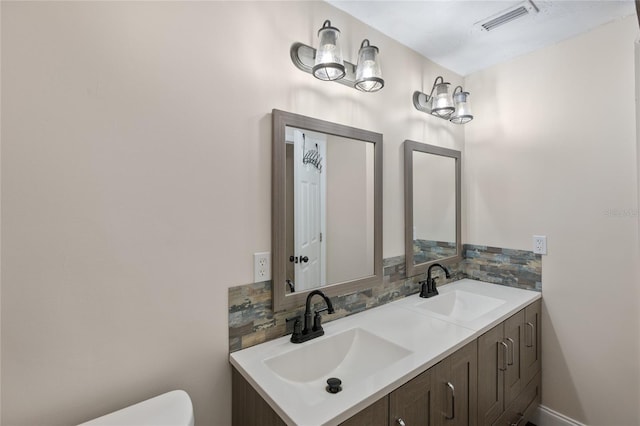 bathroom with vanity, backsplash, and toilet