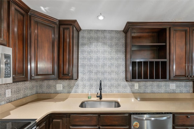 kitchen with appliances with stainless steel finishes, tasteful backsplash, dark brown cabinets, and sink