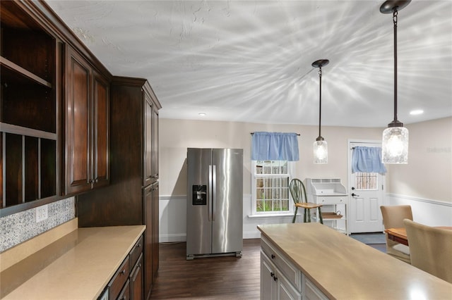 kitchen featuring stainless steel refrigerator with ice dispenser, dark hardwood / wood-style floors, dark brown cabinets, and pendant lighting